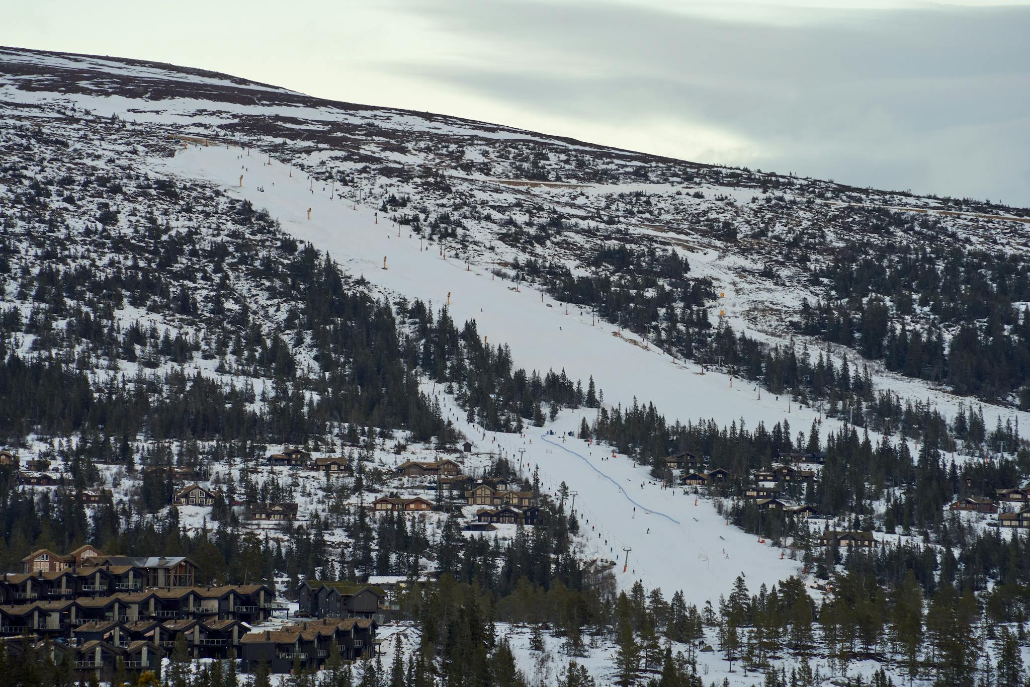 A breathtaking aerial view of the snow-covered Norefjell ski resort in Buskerud, Norway, featuring ski slopes and mountain cabins.