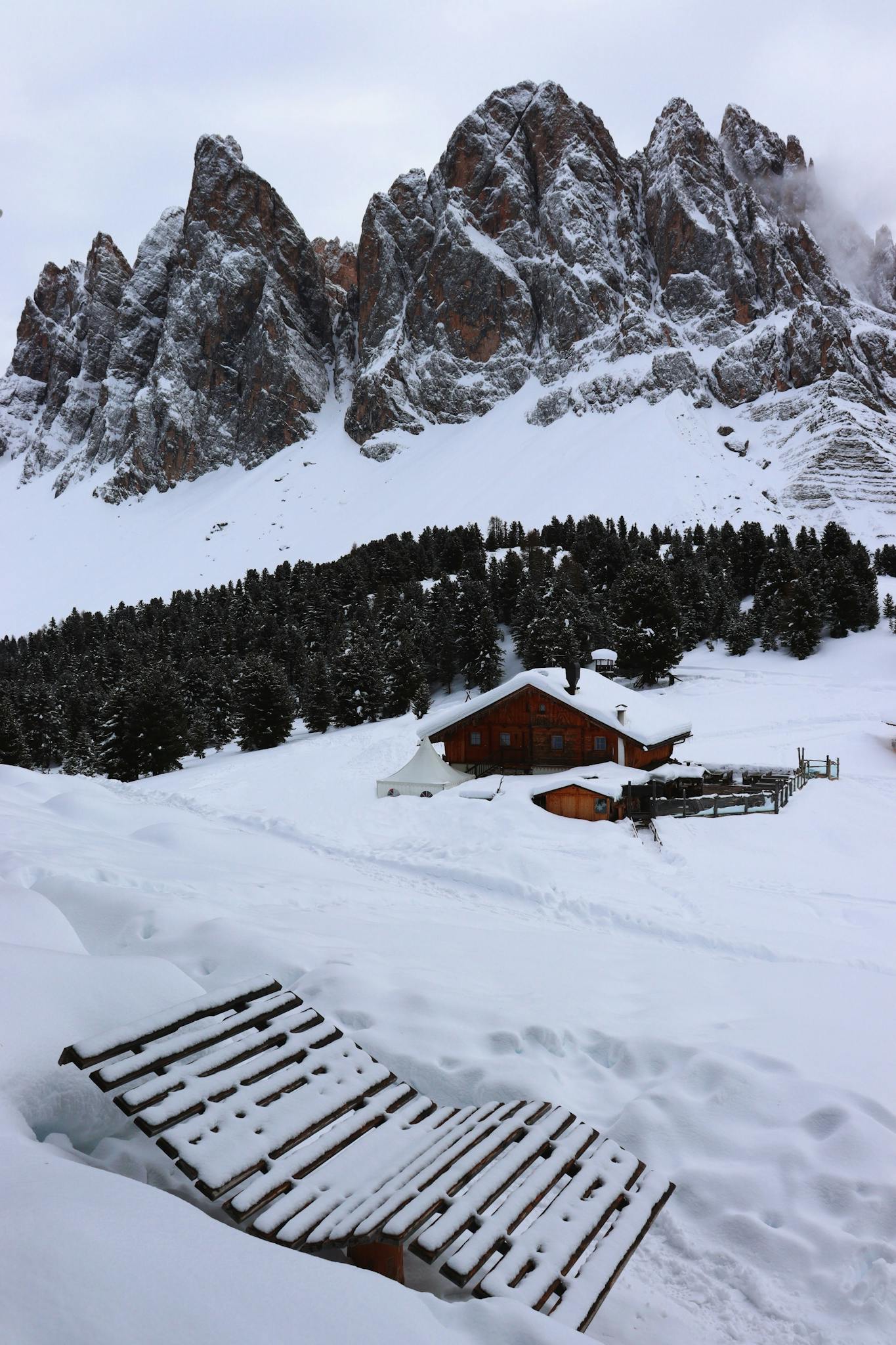 Rustic cabin surrounded by snow in the majestic Trentino-South Tyrol mountains.
