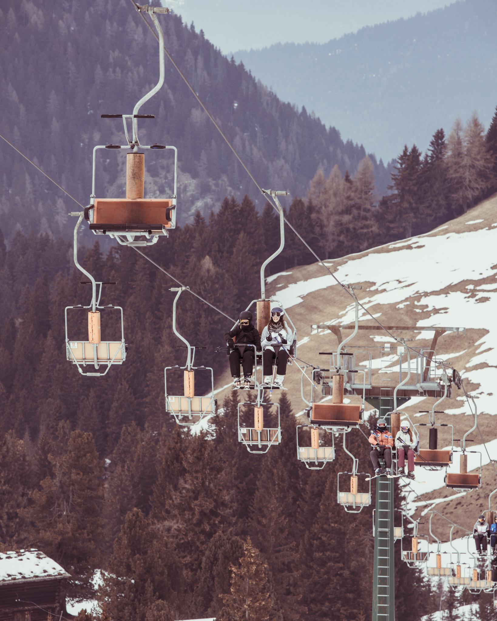 Skiers enjoy a scenic chairlift ride in the snowy Dolomite mountains, Trentino-Alto Adige, Italy.