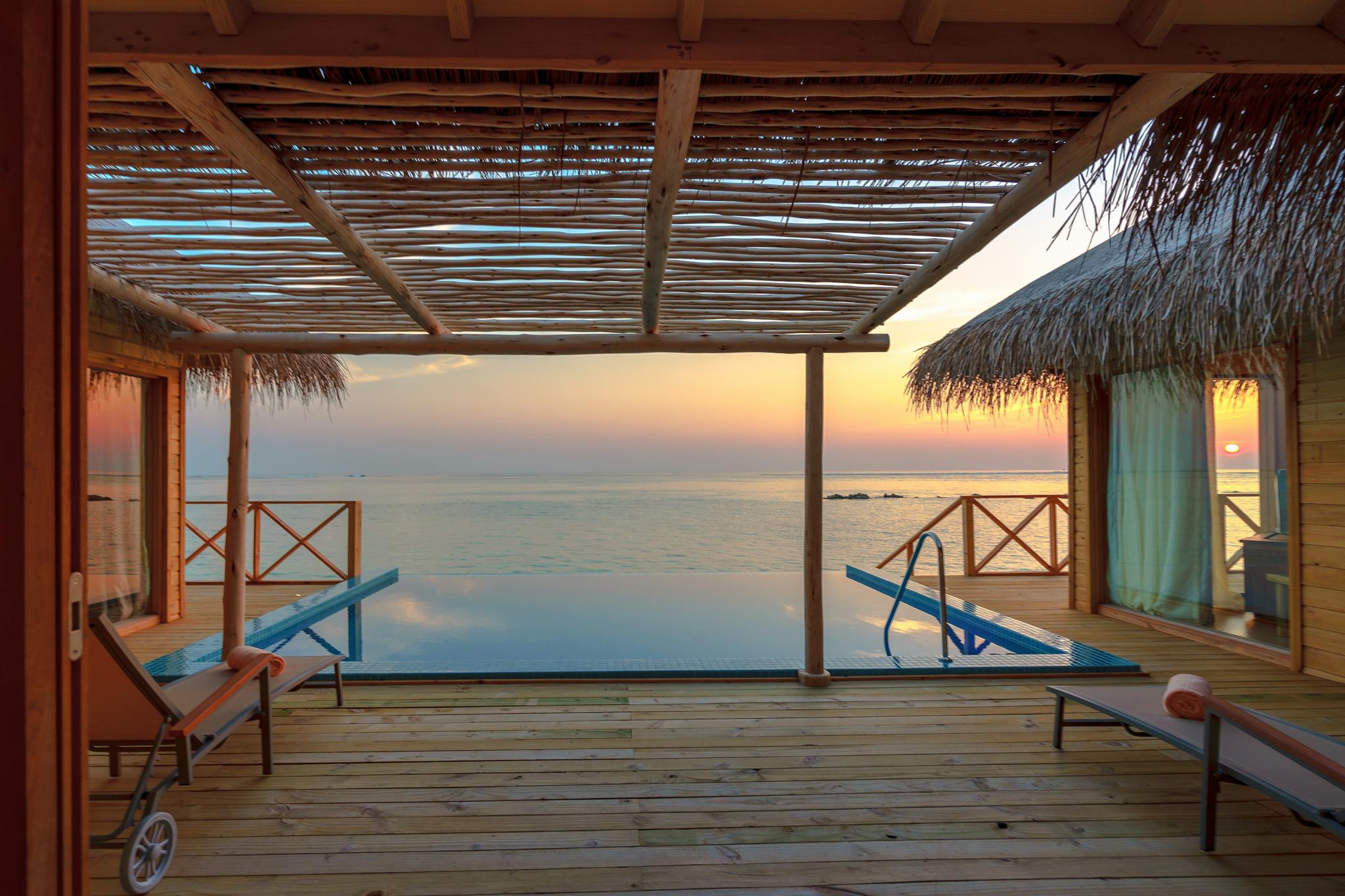 Stunning view of a luxury overwater villa in the Maldives at sunset, perfect for a tropical vacation.